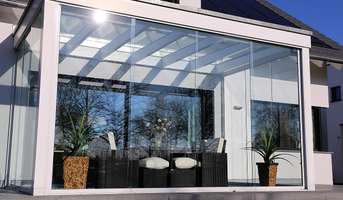 A glass patio door showcases a charming outdoor area with a table and chairs arranged for relaxation